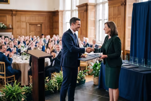 Awards and recognition ceremony, trophy presentation on stage — Event imagery.