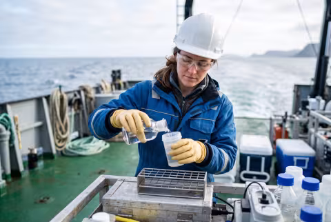 Researcher processing a water sample aboard a vessel — Person `main_image`, student/researcher.